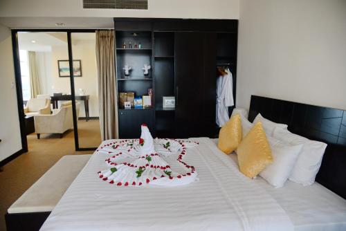 a white bed with a flower arrangement on it at Sai Gon Ban Me Hotel in Buon Ma Thuot