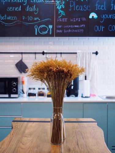 a vase filled with dried grass sitting on a table at Luck Esan Loft in Ubon Ratchathani