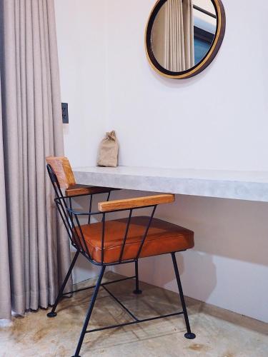 a table with a chair and a mirror at Luck Esan Loft in Ubon Ratchathani