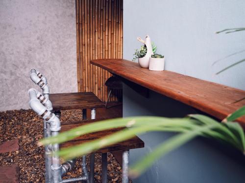a wooden table with two potted plants on it at Luck Esan Loft in Ubon Ratchathani