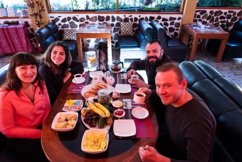 a group of people sitting at a table with food at Peru Quechua's Lodge Ollantaytambo in Ollantaytambo