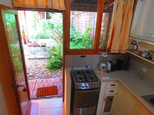 a kitchen with a stove and a door to a yard at Boulevard 251 Riverside Apartments in Iquitos