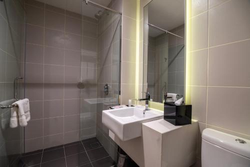 a bathroom with a sink and a mirror at Ramada Meridin Johor Bahru in Nusajaya