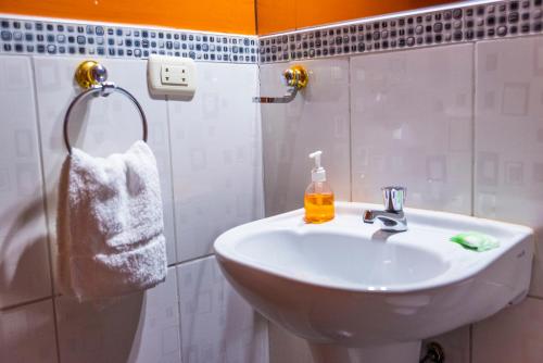 y baño con lavabo blanco y ducha. en Peru Quechua's Lodge Ollantaytambo, en Ollantaytambo