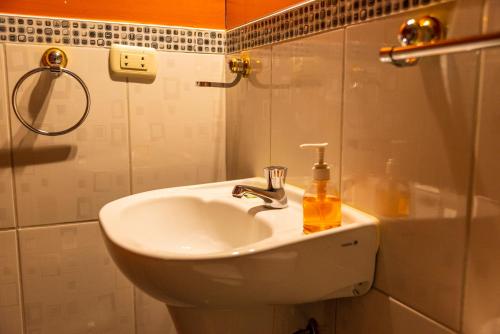 a bathroom sink with a bottle of soap on it at Peru Quechua's Lodge Ollantaytambo in Ollantaytambo