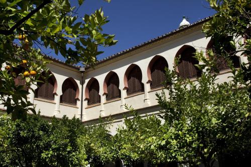 a white building with arched windows and trees at Parador de Guadalupe in Guadalupe