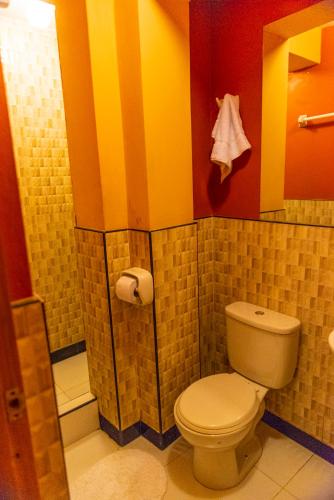 a bathroom with a toilet and colorful walls at Peru Quechua's Lodge Ollantaytambo in Ollantaytambo