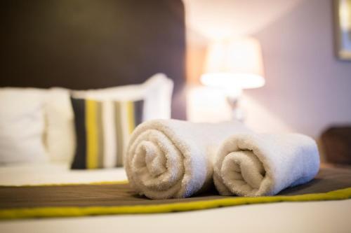 a stack of towels on a table in a hotel room at Breckland Lodge in Attleborough