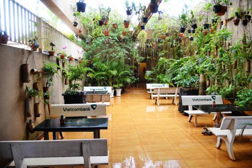 a room with tables and potted plants at Sai Gon Ban Me Hotel in Buon Ma Thuot