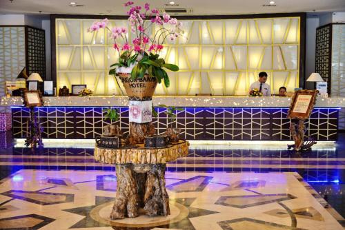 a lobby with a table with a vase of flowers on it at Sai Gon Ban Me Hotel in Buon Ma Thuot