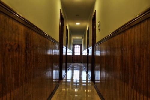 an empty hallway with wooden walls and a window at Hostal America en Puerto Natales in Puerto Natales
