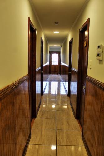 a hallway of a building with wooden doors and a hallwayngth at Hostal America en Puerto Natales in Puerto Natales