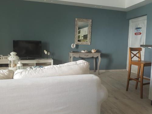 a living room with a white couch and a television at Cadaques Caribe Pez 103 in Bayahibe