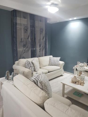 a living room with two white couches and a table at Cadaques Caribe Pez 103 in Bayahibe