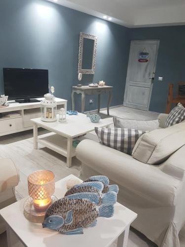 a living room with couches and tables and a tv at Cadaques Caribe Pez 103 in Bayahibe