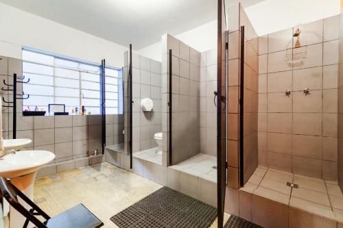 a bathroom with a shower and a sink at Tequila Sunrise Hostel in Guatemala