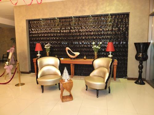 a room with two chairs and a large wall of wine bottles at Buyuk Saruhan Hotel in Manisa
