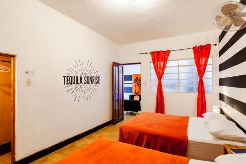 a bedroom with two beds and a sign on the wall at Tequila Sunrise Hostel in Guatemala