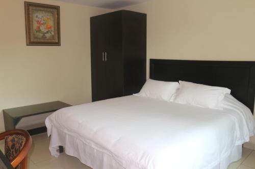 a bedroom with a white bed and a black cabinet at Hotel F Sur Inn in David