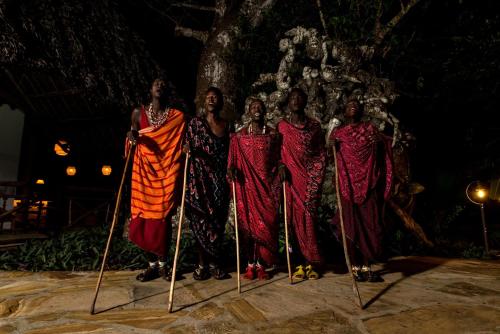a group of women standing in front of a tree at Tikitam Palms Boutique Hotel in Pongwe