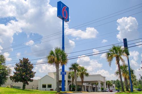 a no parking sign on a blue pole with palm trees at Motel 6-Saraland, AL in Saraland