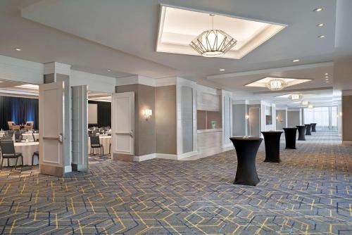 a hotel lobby with tables and chairs and a chandelier at Best Western Parkway Hotel Toronto North in Richmond Hill