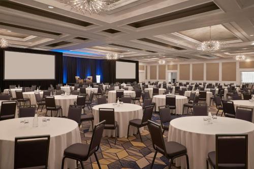 a conference room with white tables and chairs and a screen at Best Western Parkway Hotel Toronto North in Richmond Hill