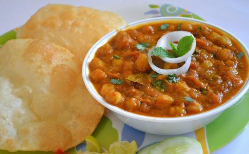 a plate with a bowl of soup and some bread at Olive suites in Patna