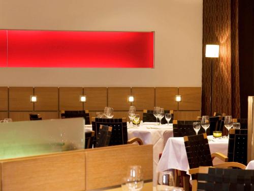 a restaurant with white tables with glasses of wine at Pullman Cologne in Cologne