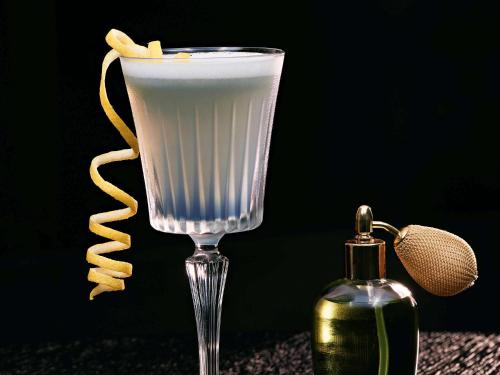 a drink in a glass next to a bottle of perfume at Pullman Cologne in Cologne
