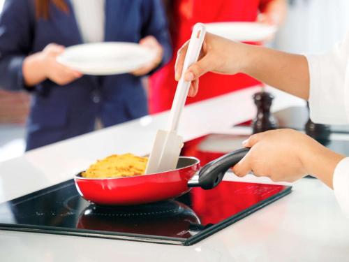 a person is stirring a bowl of food with utensils at Novotel Abu Dhabi Gate in Abu Dhabi
