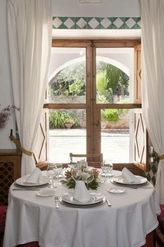 a table with a white table cloth and a window at Parador de Guadalupe in Guadalupe