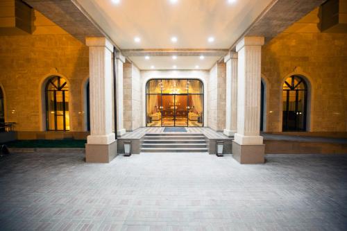 an empty lobby with a staircase in a building at Kainar Hotel in Shymkent