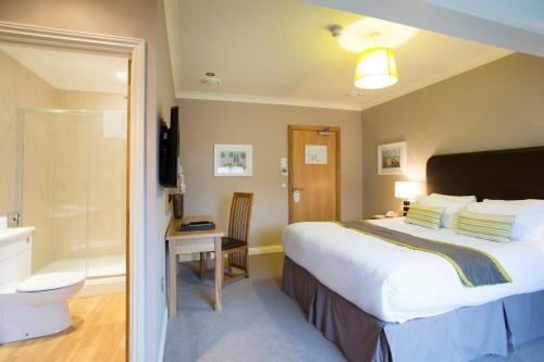 a hotel room with a bed and a toilet at Breckland Lodge in Attleborough