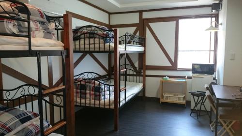 Pokój z 4 łóżkami piętrowymi i biurkiem w obiekcie Village BFH w mieście Omura