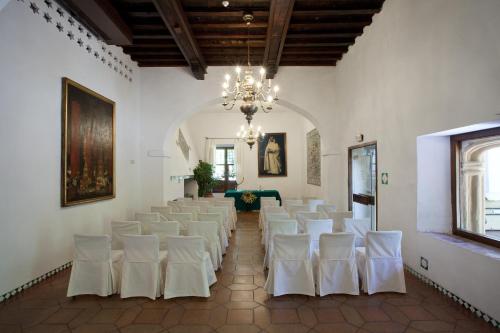 a room with white chairs and a chandelier at Parador de Guadalupe in Guadalupe