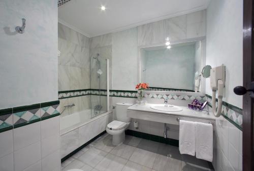 a bathroom with a sink and a toilet and a mirror at Parador de Guadalupe in Guadalupe