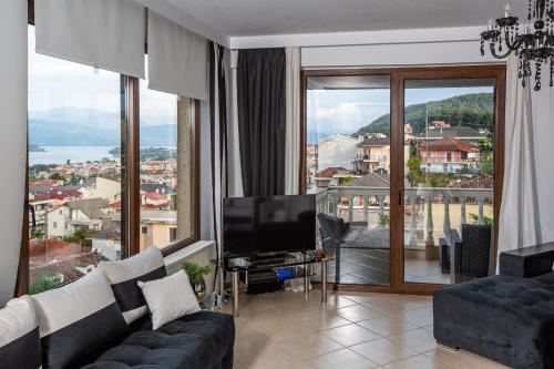 a living room with a tv and a large window at Villa Deluxe Sight in Ioannina