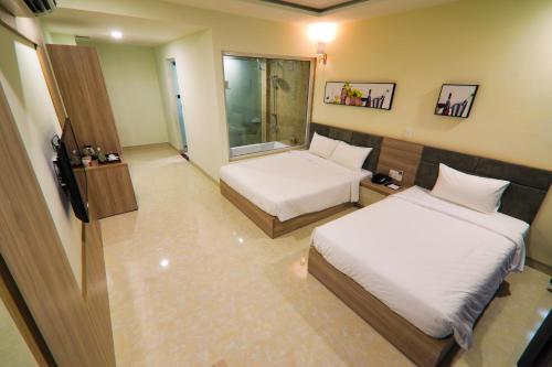a hotel room with two beds and a window at Lake View Hotel in Quy Nhon