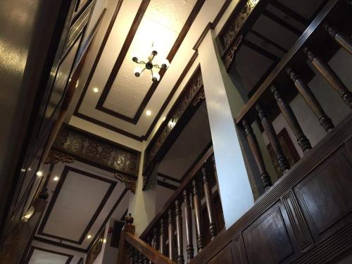 a stairway with wooden railings and a ceiling at Hotel Veneto De Vigan in Vigan