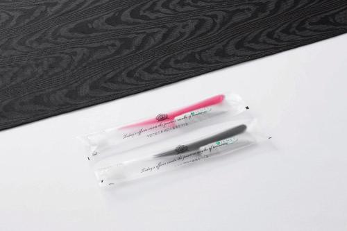 two toothbrushes in a plastic container next to a mirror at APA Hotel Sagaeki Minamiguchi in Saga
