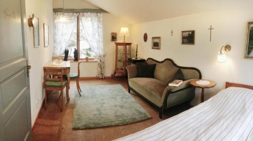 ein Wohnzimmer mit einem Bett, einem Sofa und einem Tisch in der Unterkunft FeWo Paramaribo in Witzenhausen