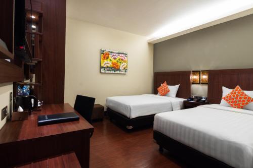 a hotel room with two beds and a desk at Best Western Senayan in Jakarta