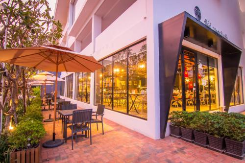 a patio with tables and chairs and an umbrella at Damrei Residence & Spa in Siem Reap