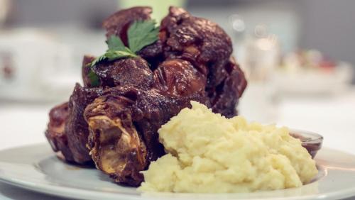 a plate of food with mashed potatoes and meat at Machauka Lodge in Lephalale