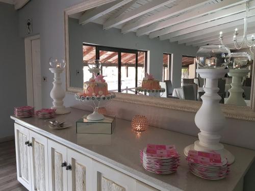 a room with a counter with plates and a mirror at Machauka Lodge in Lephalale