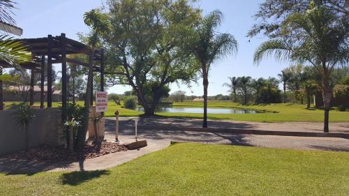 a park with a pavilion next to a lake at Machauka Lodge in Lephalale