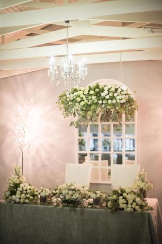 a table with a chandelier and white flowers at Machauka Lodge in Lephalale