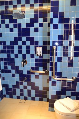 a bathroom with a blue and black tiled wall at Lagùn Hotel in El Nido