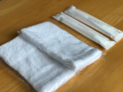 three white towels in a box on a wooden floor at Fureai No Yado Yasuragi in Nozawa Onsen